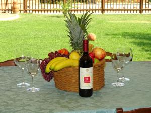 拉戈堡拉凯奥利农庄乡村民宿的一张桌子上摆放着一瓶葡萄酒,还有一篮水果
