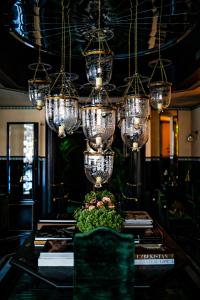 巴黎Monsieur George Hotel & Spa - Champs-Elysées的用餐室配有带吊灯的桌子