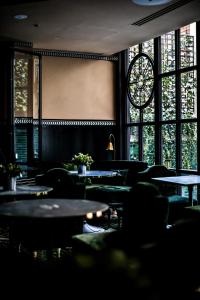 巴黎Monsieur George Hotel & Spa - Champs-Elysées的客房设有桌椅和窗户。