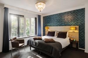 赫鲁斯贝克沃尔夫斯堡餐厅酒店的一间卧室配有一张大床和一个吊灯。