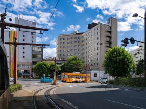 冈山The OneFive Okayama的一辆橙色的巴士驶向城市的街道