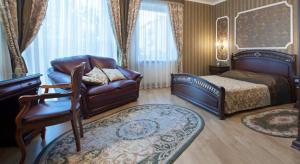克列缅丘格直升机酒店的一间卧室配有一张床、一张沙发和一把椅子
