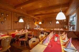 科琴斯顿巴赫苏姆阿特施罗斯兰迪伊尔酒店的餐厅设有木桌和椅子及灯