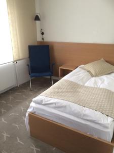 欧登塞弗雷德里克六世酒店的一间卧室配有一张床和一张蓝色椅子