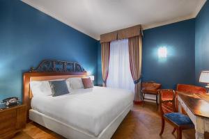 巴尼奥维尼奥尼阿尔伯格玛库奇旅馆的卧室配有白色的床、书桌和书桌。