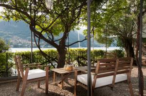 卡拉泰乌廖尼娜雷莱斯别墅精品住宿加早餐旅馆的桌子和两把椅子坐在树边