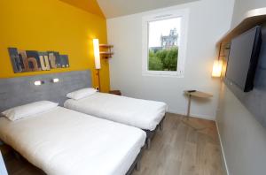 欧塞尔ibis budget Auxerre Centre的配有电视和窗户的客房内的两张床