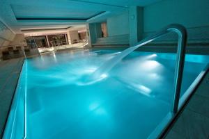 什平德莱鲁夫姆林和谐俱乐部酒店的蓝色灯光的酒店游泳池