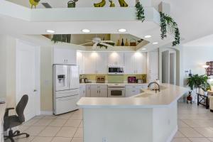 珊瑚角Villa Bel Air的厨房配有白色橱柜和白色冰箱。