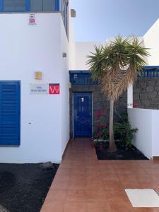 普拉亚布兰卡布里萨德尔马别墅的一座拥有蓝色门和棕榈树的建筑