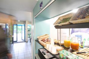 沙斯讷伊迪普瓦图Kyriad Direct Poitiers - Gare du Futuroscope的餐厅设有食品和饮料柜台