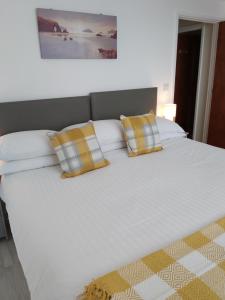 纽基Trevarrian Lodge的一张大白色的床,上面有两个黄色的枕头