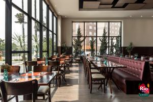 圣若泽杜斯皮尼艾斯里约博本库里蒂巴机场酒店的餐厅设有桌椅和大窗户。