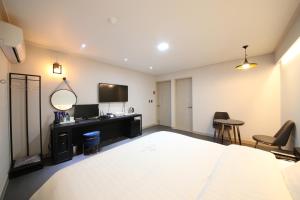 木浦市木浦贵宾酒店的一间卧室配有一张床、一台电视和椅子