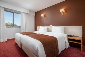 莱里亚圣路易斯酒店的酒店客房设有两张床和窗户。