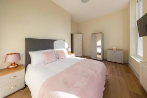 赫里福德Apartment 1 Isabella House, Aparthotel, By RentMyHouse的卧室配有带粉红色枕头的大型白色床