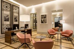 佛罗伦萨奥托迪梅帝齐酒店的办公室设有粉红色的椅子和一张带电脑的桌子