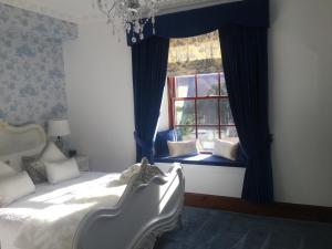 罗伊桥格伦史宾洛奇酒店的一间卧室配有床和蓝色窗帘的窗户