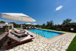 DafnilaLuxury Corfu Villa Villa Jasmine Private Pool 4 BDR Dassia的一个带躺椅和遮阳伞的游泳池