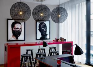 格拉斯哥格拉斯哥世民酒店的一间设有酒吧的房间,配有凳子和吊灯