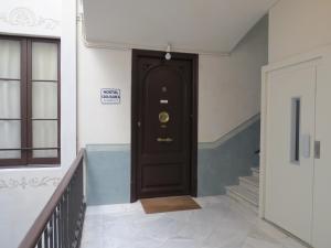 巴塞罗那卡萨布兰卡旅舍的走廊上设有一扇黑色门,有楼梯