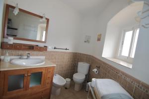特鲁希略Apartamentos Altozano的一间带水槽、卫生间和镜子的浴室