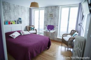 阿布维尔双桥花园酒店的一间卧室配有紫色的床、椅子和窗户