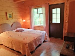 塔库沃里Tahkonhovi Golden Chalet的木屋内的卧室配有一张床