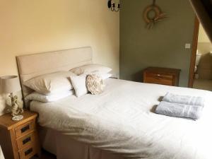 WiggintonOak Barn的卧室配有一张带两个枕头的大白色床