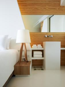 梅尔皮姆罗勇盛泰乐萨帕雅度假村的一间卧室配有一张床和一张带台灯的桌子