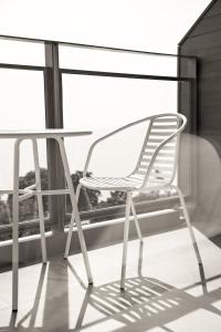 梅尔皮姆罗勇盛泰乐萨帕雅度假村的阳台桌子旁的白色椅子