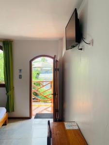阿约拉港加拉帕戈斯白色旅舍的一间用餐室,配有一张桌子和一台墙上的电视