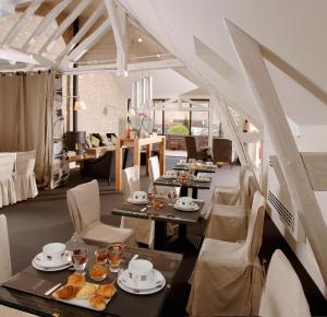 沙布利Au Vieux Moulin的用餐室配有桌椅和食物