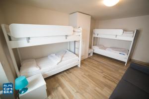 福尔加里亚Trentino Apartments - Casa Marzari的铺有木地板的小客房内设有两张双层床。