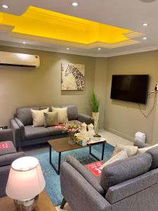 沙迦Al Rawdha Hotel Apartments的带沙发和平面电视的客厅