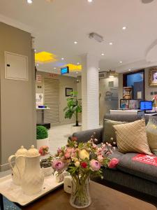 沙迦Al Rawdha Hotel Apartments的客厅配有沙发和鲜花桌