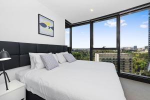 布里斯班Brisbane Skytower by CLLIX的卧室设有白色的床和大窗户