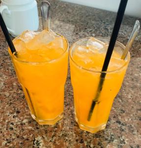 芹苴Mekong Rose Hotel的两杯橙汁坐在柜台上