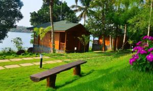 卡尔佩特塔Room in Villa - LakeRose Wayanad Resort的坐在房子前面的草上木凳