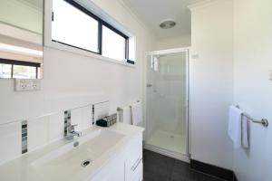霍尔斯加普霍尔斯加普汽车旅馆的白色的浴室设有水槽和淋浴。