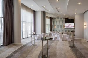 迪拜Crowne Plaza Dubai Festival City的用餐室配有桌子和白色椅子