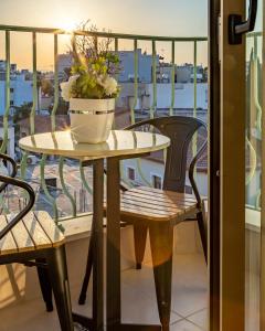 拉纳卡Leonardo Boutique Hotel Larnaca的阳台上的桌子上放着盆栽植物