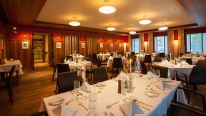 卡塞尔古德酒店的一间设有白色桌椅的用餐室