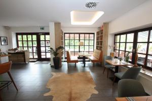 帕滕森zeitlos Hotel und Restaurant am Fuchsbach的一间设有桌椅和地毯的餐厅