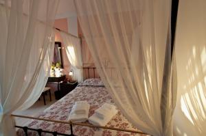 卡特瑞杜斯亚缇米斯田园酒店的卧室配有带白色窗帘的天蓬床
