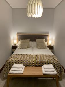 毕尔巴鄂La puerta verde - CASCO VIEJO-OLD TOWN的一间卧室配有一张大床和两张折叠毛巾