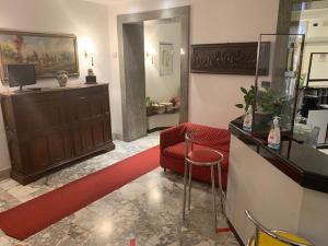 罗马可鲁西迪马耳他酒店的客厅配有红色椅子和柜台