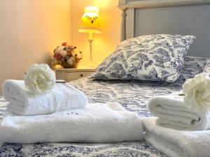 米雷Le Moulin de Rudelle的床上配有毛巾、枕头和灯