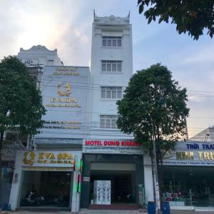 Dĩ AnDung Khanh Motel的一座高大的白色建筑,上面有标志