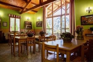 ValcarlosCASA RURAL TOKI ONA的一间拥有绿色墙壁和木桌及椅子的用餐室